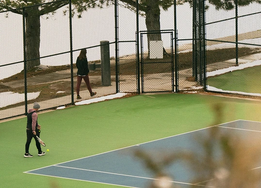 Person preparing to hit a tennis ball on an outdoor court